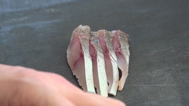 Sliced raw mackerel on a cutting board