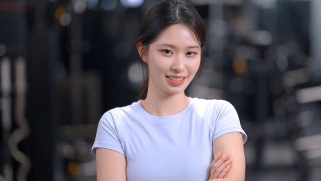 Young woman smiling with arms crossed in gym