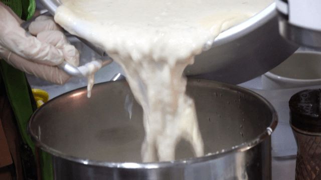 Rice pudding being poured into a pot