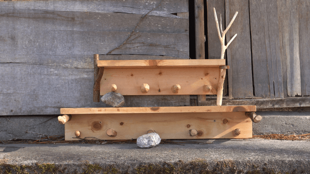 Stacked wooden shelves leaning against a rough wooden wall