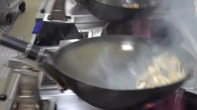 Robot stir-frying vegetables in the kitchen
