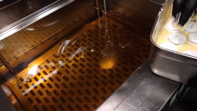 Cookies being dipped in batter and fried