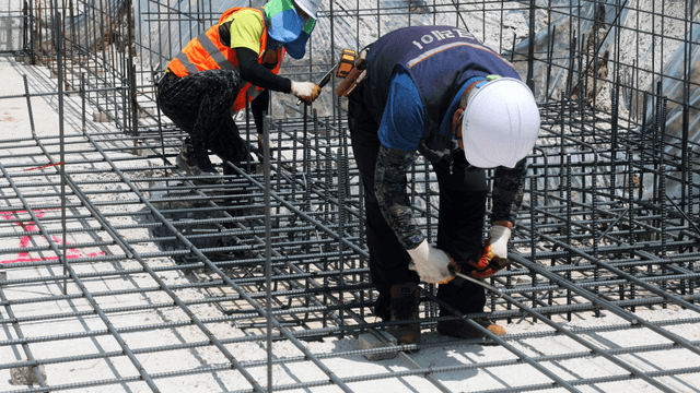 Construction workers assembling rebar