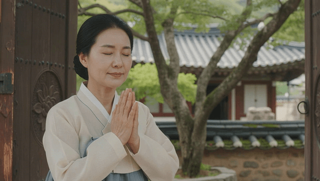 Hanbok woman praying at a traditional Korean temple