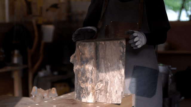 Carpenter lifting a large wooden log block