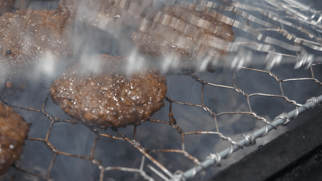 Grilled short rib patties cooking neatly on a grill