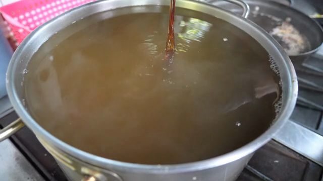 Soy sauce being poured into a large pot