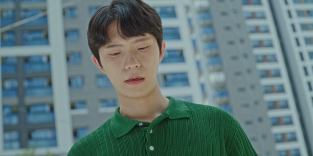 고층 건물 앞에서 난감한 표정의 남자