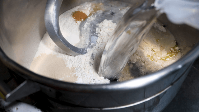 Water and coloring mixture poured into large mixer