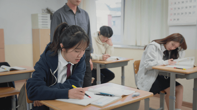 Teacher answering students’ questions while they study in the classroom