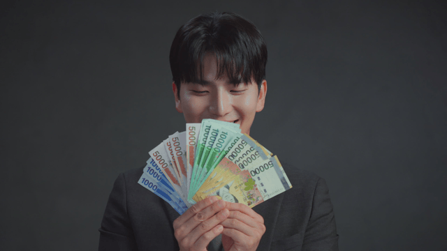 Man holding Korean banknotes with a smile