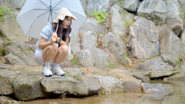계곡을 즐기는 우산을 쓴 여성