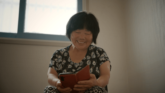 A woman smiling while looking at her phone