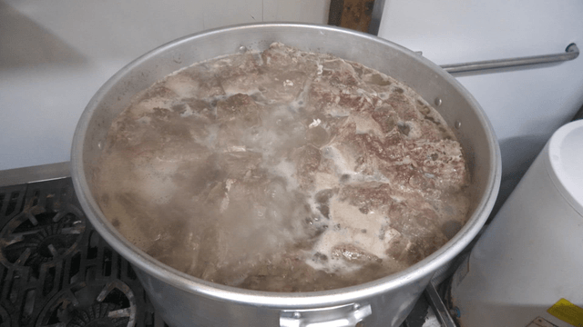 Large pot of meat boiling on the stove
