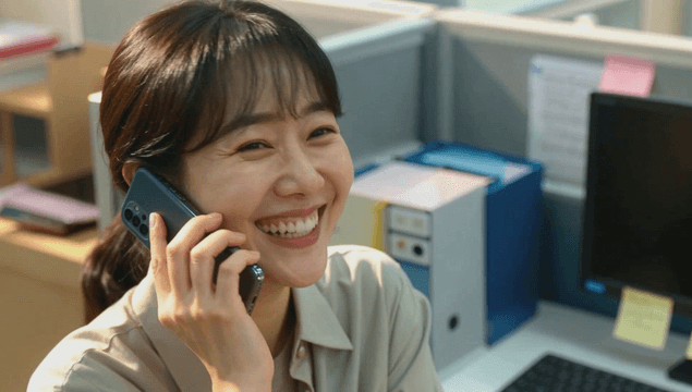 Smiling woman on a phone call in the office