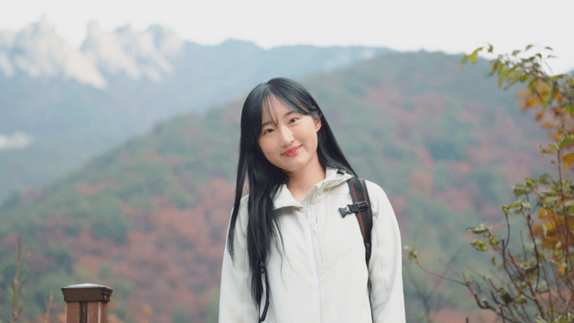 Young woman smiling while enjoying summit view in autumn mountains