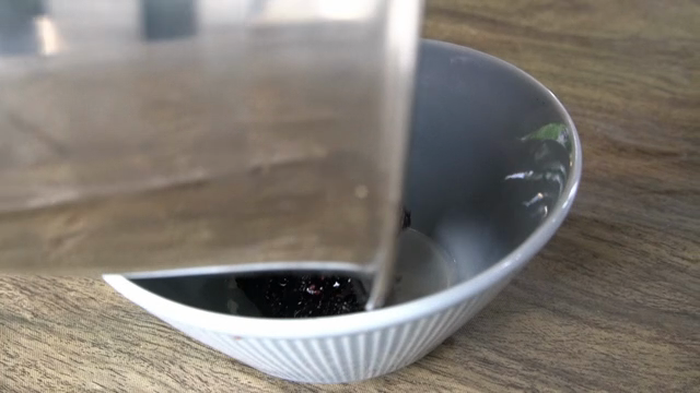 Transferring mulberry jam into a bowl