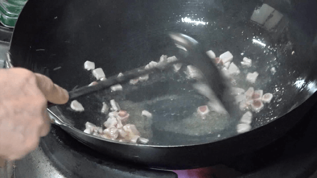 Meat being stir-fried in a hot wok
