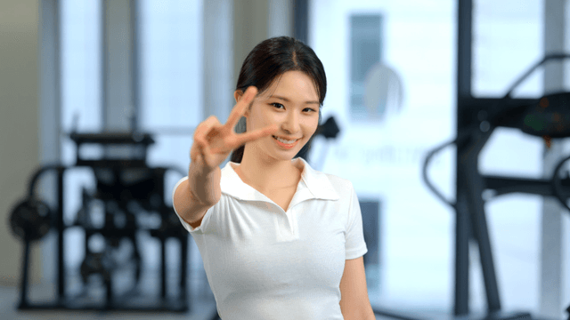 Smiling woman making a V sign in a gym