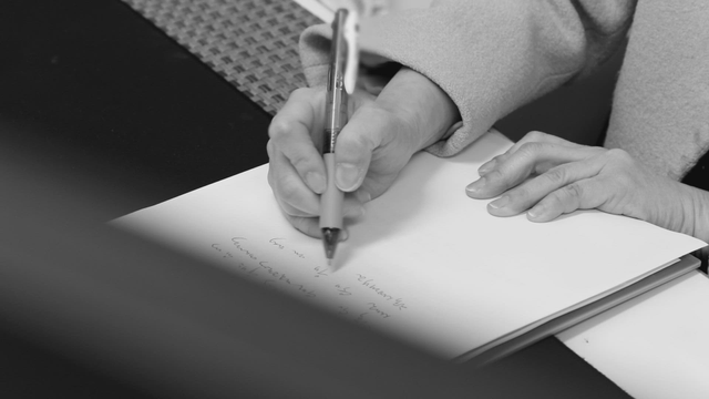 A person writing notes on a paper