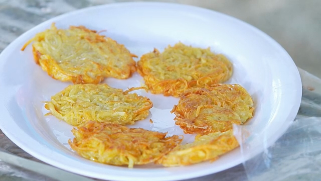 Golden potato pancakes on a white plate
