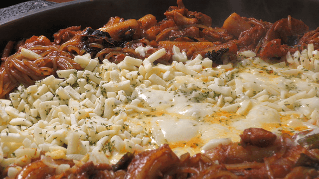 Spicy stir-fried chicken covered with cheese