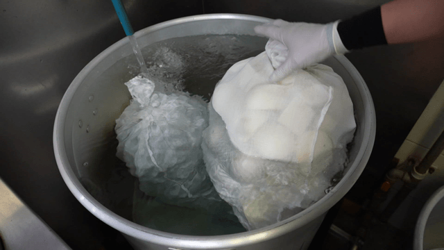 Broth bag being added to a large pot