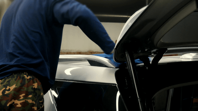 Worker cleaning a car with a cloth