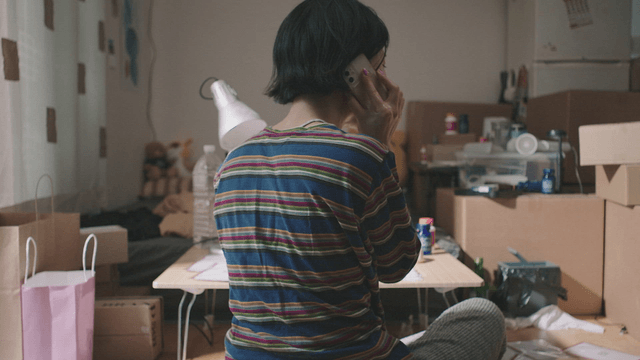 Person talking on the phone in a cluttered room