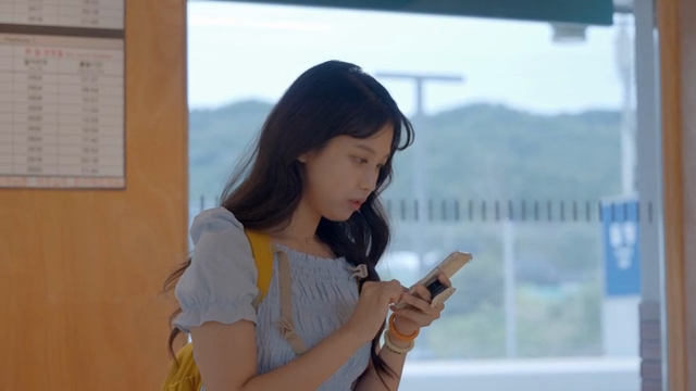 Woman checking her phone at a station
