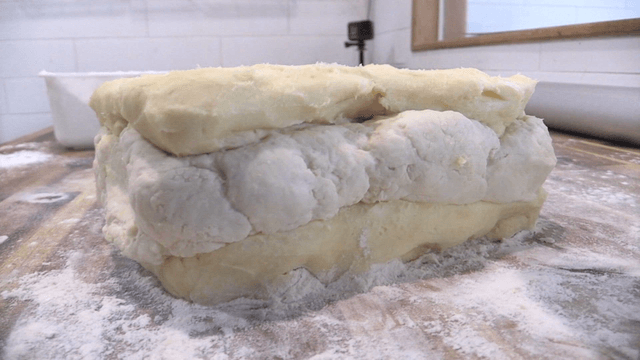 밀가루를 뿌린 나무 조리대 위의 반죽