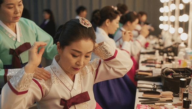 Women in hanbok preparing in front of a dressing table