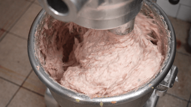Ground meat blended smoothly in large mixer