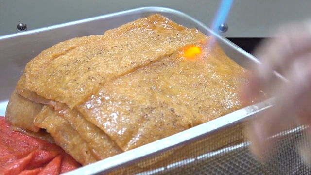 유부 표면을 토치로 굽는 장면