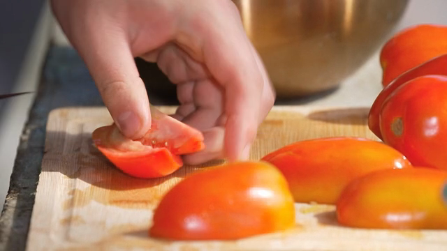 Slicing fresh tomatoes on a cutting board