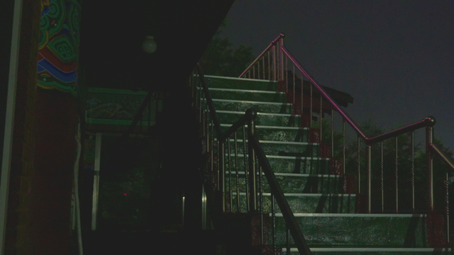 Rain falling on temple stairs at dark night