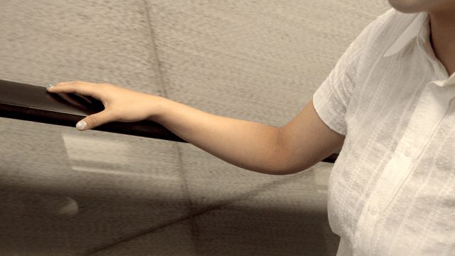 Person holding the handrail on an escalator