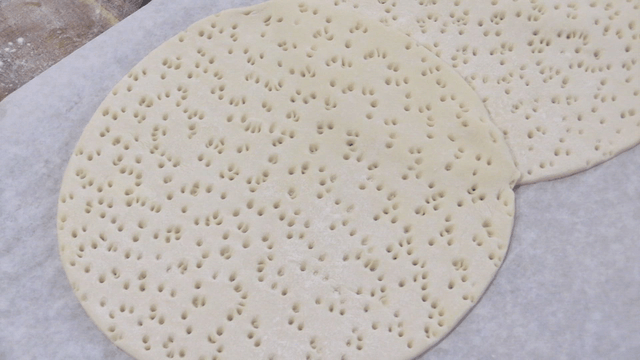 종이호일 위에 구멍이 있는 평평한 반죽들