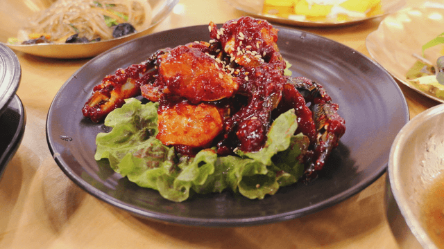 접시에 담긴 상추 위 매운 양념 게장