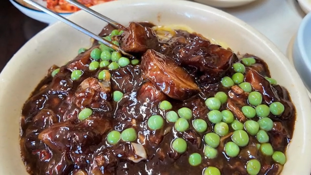 A bowl of jajangmyeon with peas