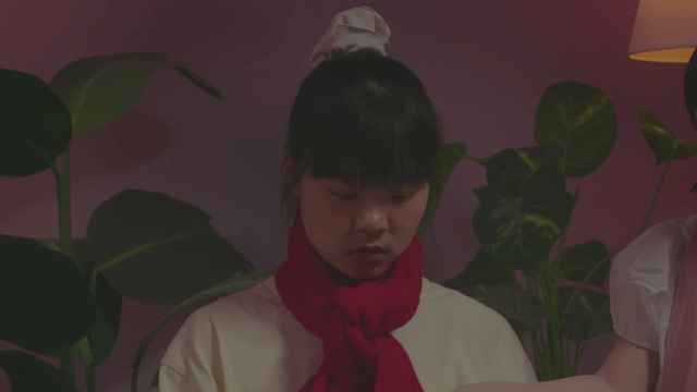 Girl turning on the TV with a remote control in her room