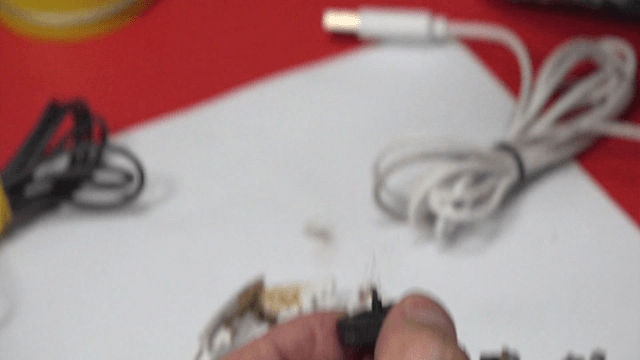 Tweezers removing tangled thread from a computer mouse wheel