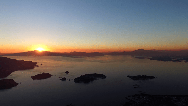 Sunrise over a calm sea with islands
