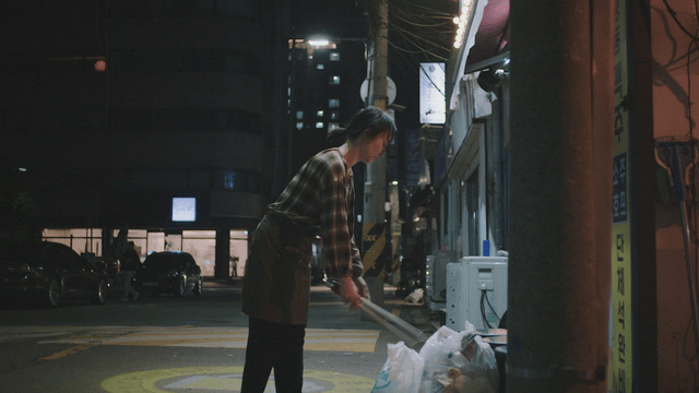 Woman disposing of trash at night