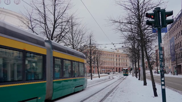 A tram moving through a snowy city street