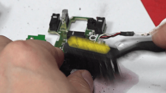 Cleaning circuit board with a brush