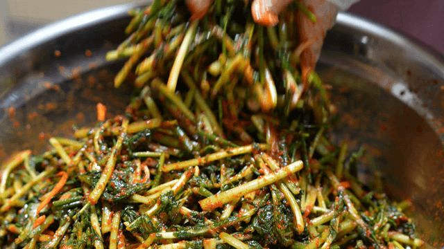 Mixing yeolmukimchi with seasoning in a basin
