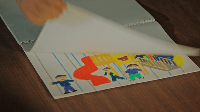 A hand flipping through a sketchbook