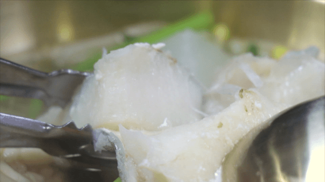 Splitting cod soup fillet with tongs and spoon