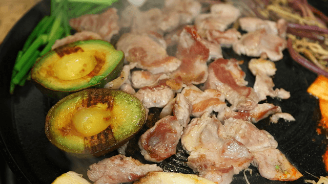 Grilled pork and avocado on a hot plate